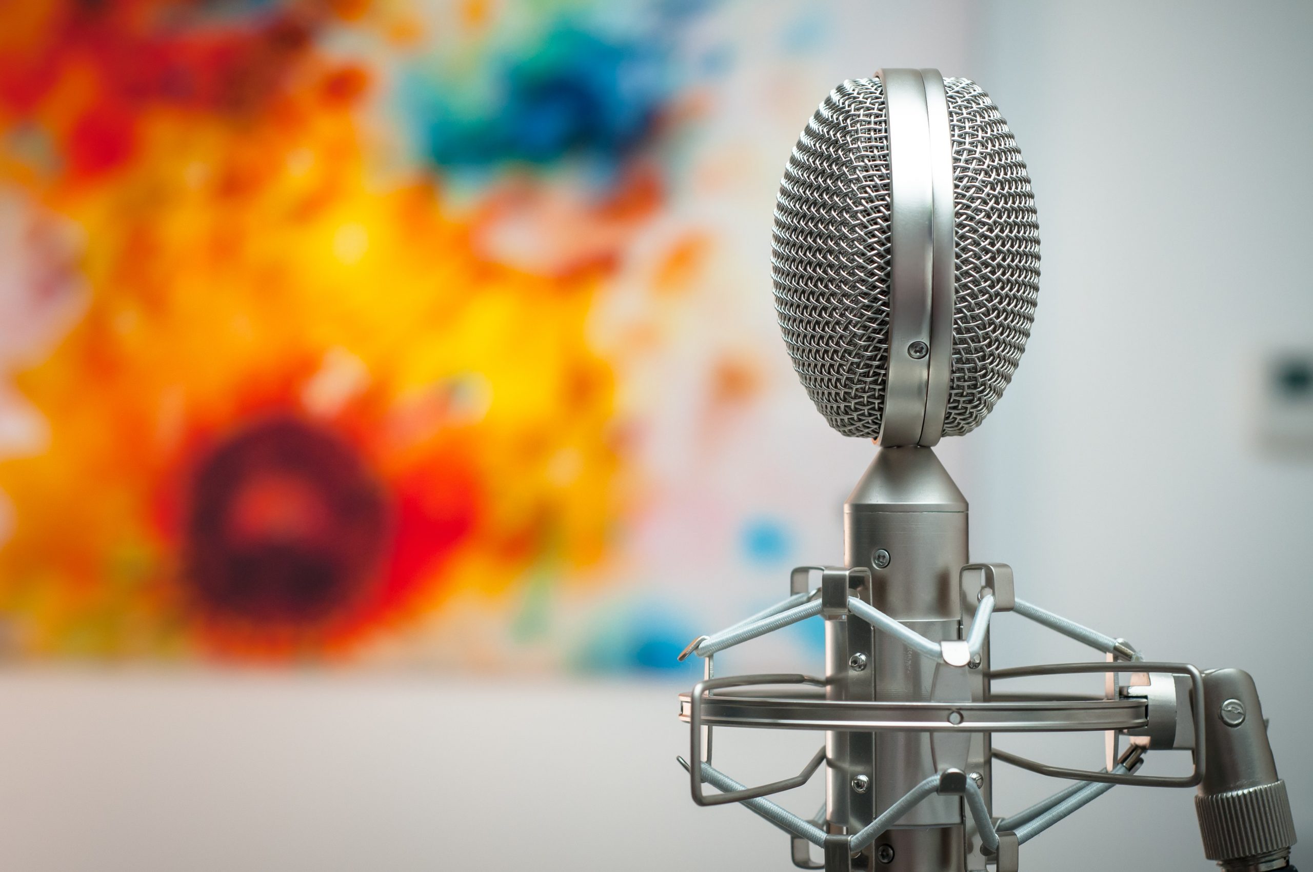 Microphone in front of a tie-dyed screen.